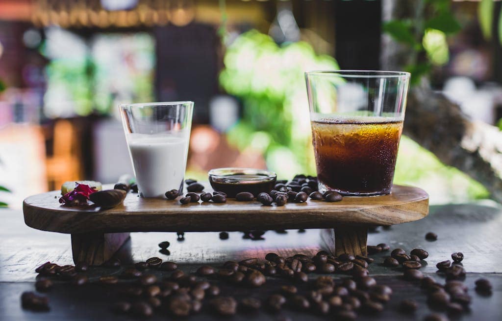 How to Make Coffee Less Acidic: Easy Tips You Can Use at Home 5 Glass of cold coffee served with milk and beans