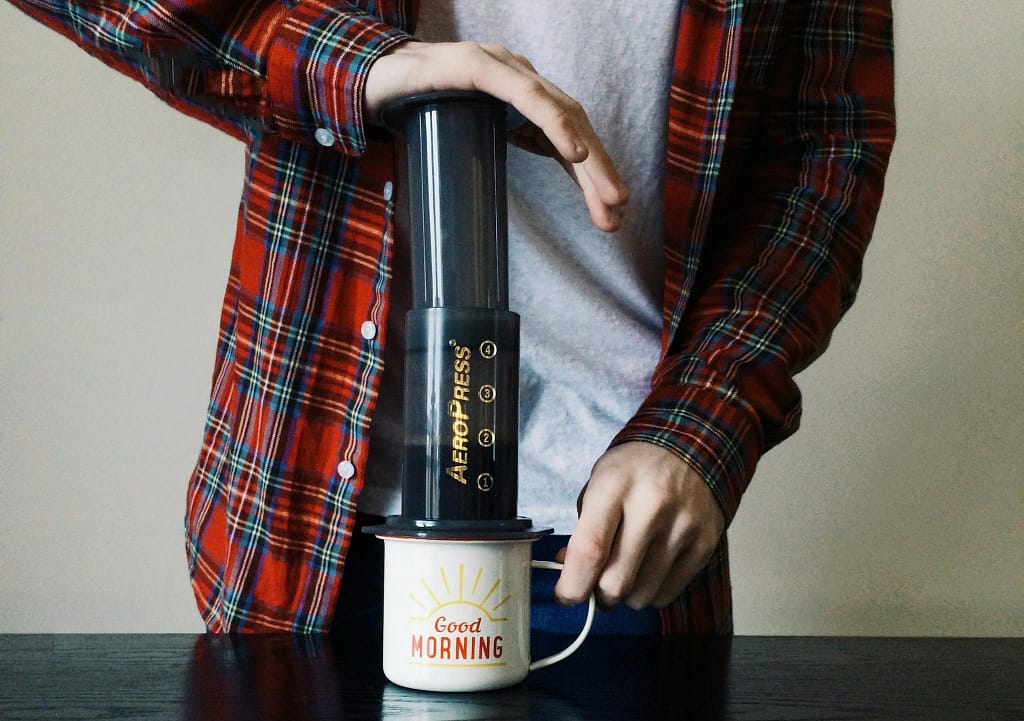 Aeropress vs French Press: Which Brews the Best Cup? 18 A Person Wearing Plaid Long Sleeves Making a Cup of Coffee