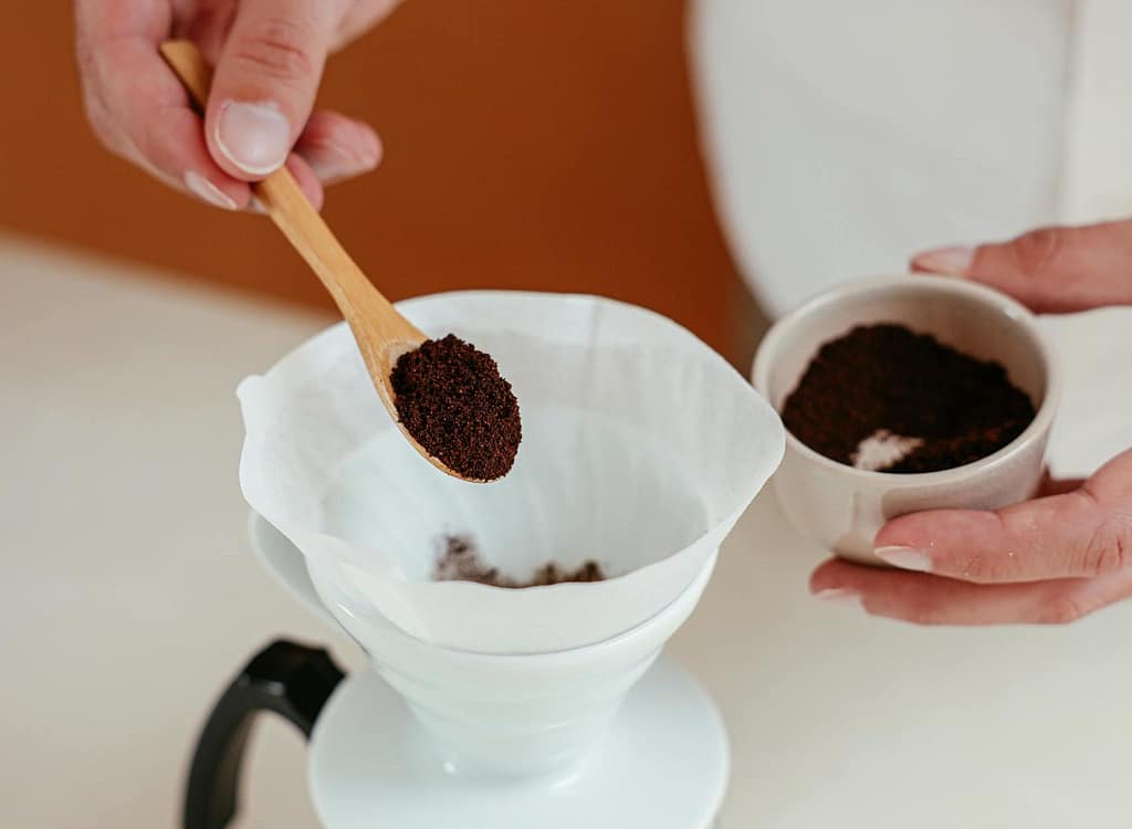 How to Grind Coffee Beans for a Perfect Brew 4 A Person Putting Ground Coffee on a Pour Over Set