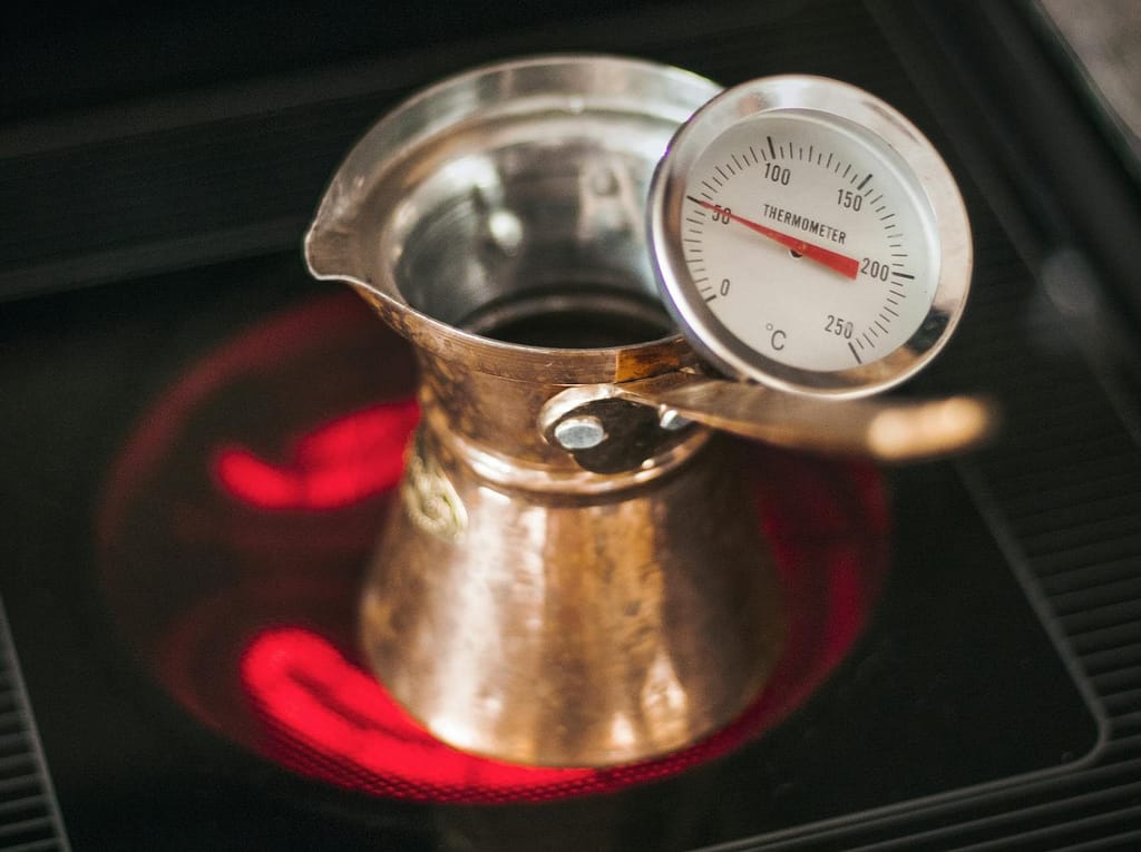 Perfect Your Brew: The Best Temperature to Brew Coffee 1 Cezve with thermometer on hot stove