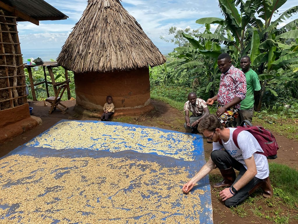 a group of people standing around a blue and yellow rug