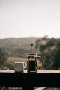 Comparing Drip Coffee vs French Press: What’s Right for You? 5 A French Press with Coffee on a Wooden Railing