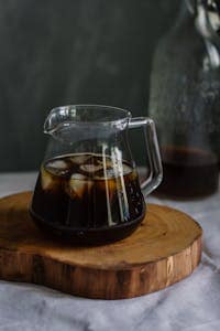 How to Make Cold Brew with French Press: Quick and Easy 11 Clear Glass Pitcher With Cola and Ice on Wooden Chopping Board