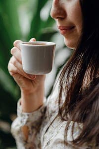 How to Make Coffee Less Acidic: Easy Tips You Can Use at Home 2 Crop woman tasting fresh coffee in cafe