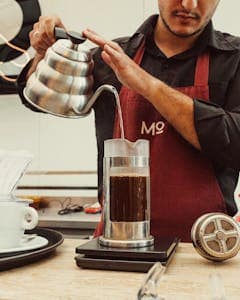 Aeropress vs French Press: Which Brews the Best Cup? 17 Barista Pouring Hot Water into French Press Jug