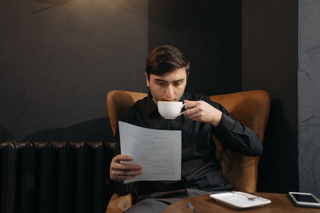 Man in Black Tank Top Reading Book